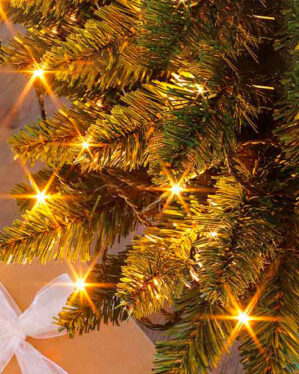 juletræ med en julegave under og en micro led der er varmhvid som dækker over