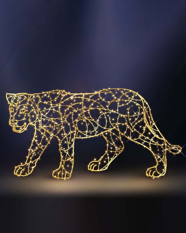 En imponerende puma-skulptur oplyst af gyldne LED-lys, der fremhæver dyrets elegante og kraftfulde silhuet på en mørk baggrund.