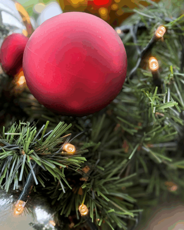 Nærbillede af granguirlande med julekugler og varm hvide LED-lys. Fanger julens hyggelige glød og de klassiske farver i elegant detalje.
