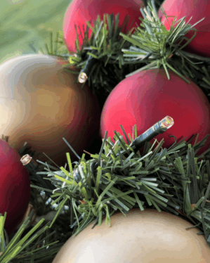 Detaljeret foto af juleguirlande med røde, champagne og guld kugler samt LED-lys. Viser naturtro gran og elegant farvespil til klassisk julepynt.