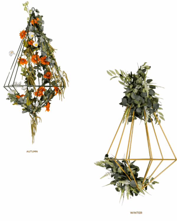Geometriske ophæng dekoreret med kunstige blomster i efterårs- og vintertema, med grønne blade og naturlige nuancer, velegnet til sæsonbaseret dekoration i moderne og stilfulde miljøer.