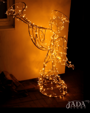 Lysende 3D-engelmotiv i varm hvid LED med trompet og vinger, vist indendørs på gulv som elegant juledekoration med klassisk og stemningsfuldt udtryk i mørke.