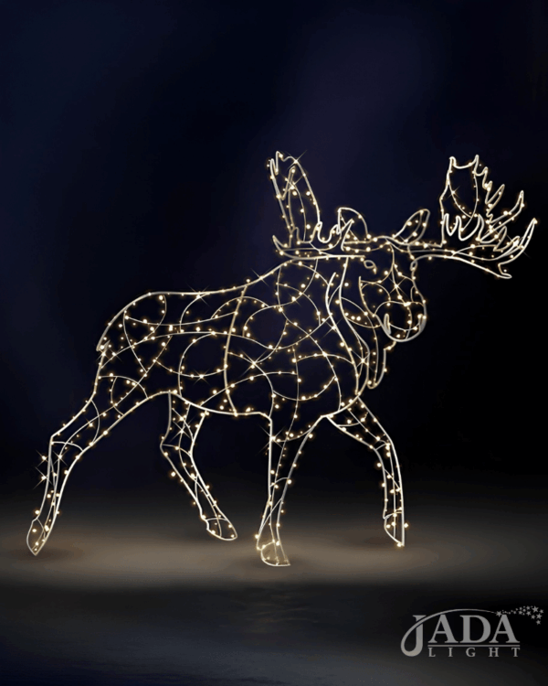 Lysende 3D-elg i varm hvid LED med åben aluminiumsstruktur og markante gevirer, vist på mørk blå baggrund som dekorativ motiv til stemningsfuld vinterudsmykning.